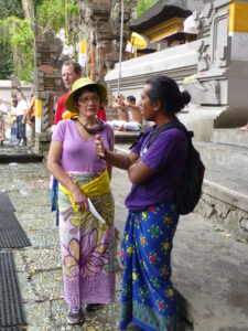 Jalu en train de présenter le temple de Tirta Empul, avec des Balinais en prière en arrière-plan